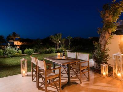 Pohodlná venkovní oblast se stolem a židlemi, osvětlená lucernami v noci