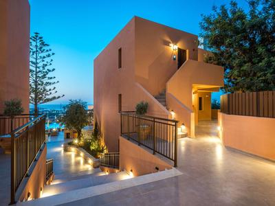 Complesso alberghiero moderno con illuminazione e vista sul mare al crepuscolo.