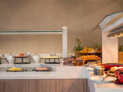 Buffetbereich mit verschiedenen Speisen, warmen Lampen und rustikaler Wandgestaltung.