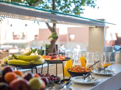 Buffet con frutta, cereali e bicchieri su un tavolo per la colazione all'aperto soleggiato