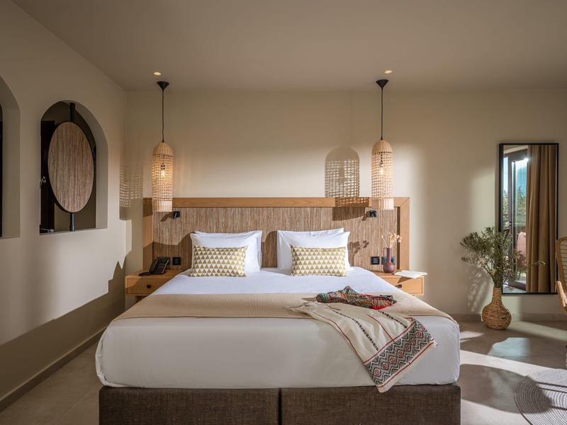 Modernes Schlafzimmer mit großem Bett, Holzdekor, Beleuchtung und gemütlicher Atmosphäre.