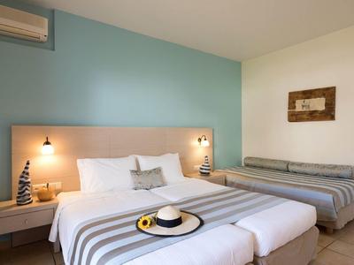 Modernes Schlafzimmer mit zwei Betten, gestreifter Bettwäsche, Holzbettrahmen und blauer Akzentwand.