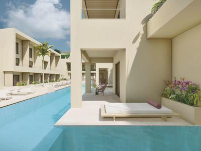 Modern hotelzwembad met ligstoelen en zonnebedden onder heldere lucht.