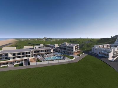 Modern hotelcomplex met zwembad en zeezicht op een zonnige dag.