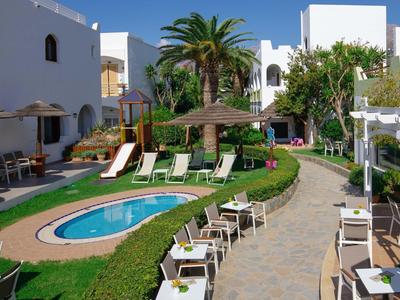 Zwembadgebied met ligstoelen, kleine zwembaden en witte gebouwen in een hotelcomplex.