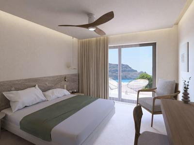 Moderne hotelkamer met tweepersoonsbed, houten meubels en terras met uitzicht op de bergen.