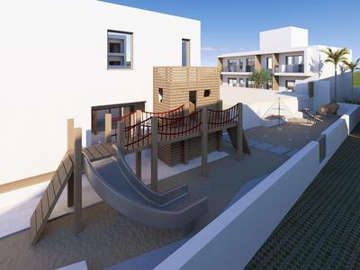 Moderne buitenruimte met klimrek en glijbanen naast witte gebouwen onder een heldere hemel.