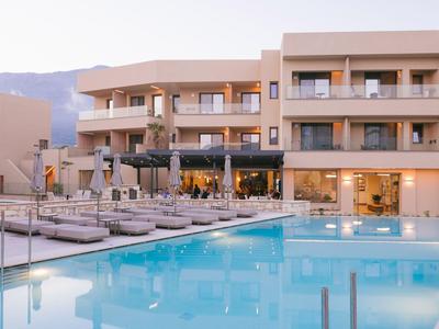 Hotel moderno con amplia zona de piscina y tumbonas en un entorno tranquilo.