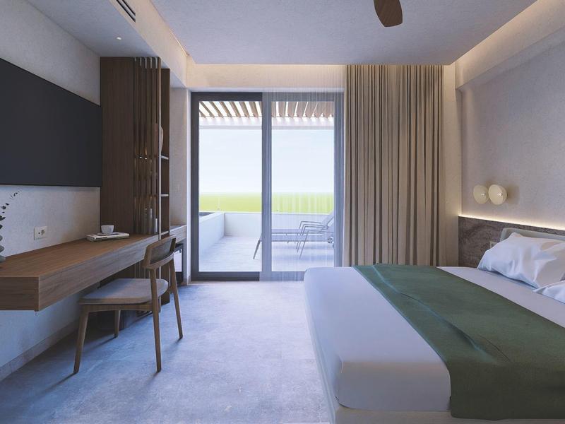 Modern hotelkamer met groot bed, bureau, tv en balkon met groen uitzicht.