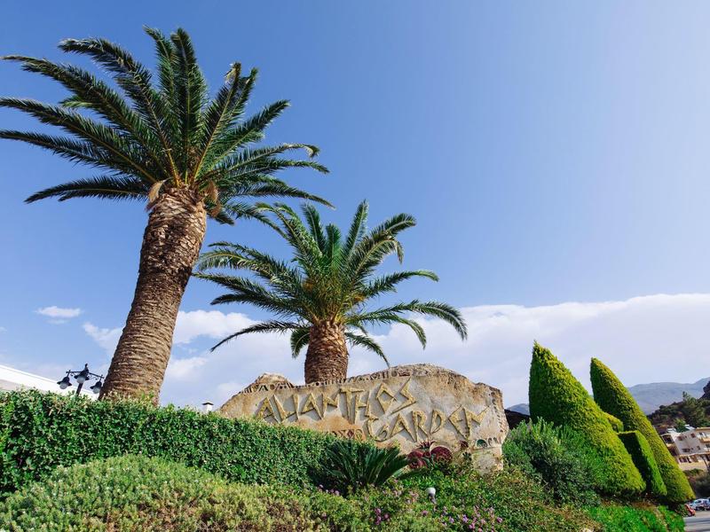 Palmbomen en groen omringen een grote steen met de tekst Palma Plaza.