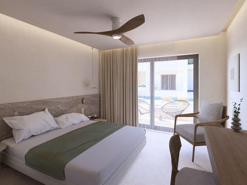 Moderne hotelkamer met tweepersoonsbed, plafondventilator, bureau en balkon met zithoek.