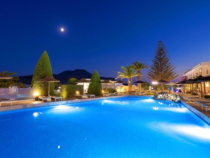 Verlicht hotelzwembad 's nachts met heldere lucht en maan