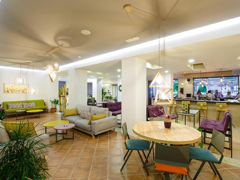 Moderne lounge met meerdere zitgelegenheden en planten als accenten.