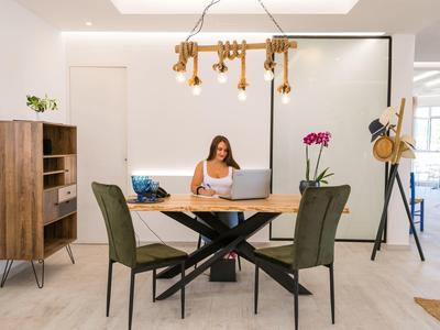 Zona pranzo moderna con tavolo, sedie e una donna seduta al tavolo.