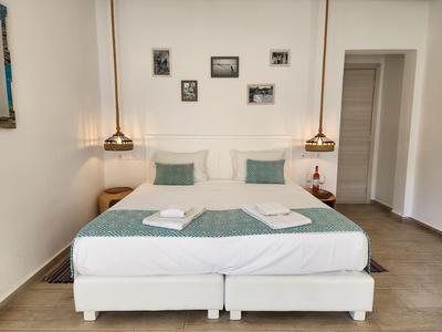 Modernes, sauberes Hotelzimmer mit Doppelbett, dekorativen Kissen und Wandbildern.