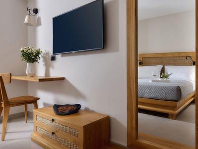 Moderne hotelkamer met wand-tv, houten stoel, ladekast en spiegel