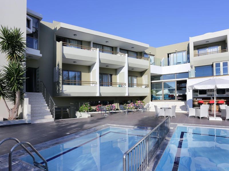 Modern hotelcomplex met zwembad, terras en meerverdiepingen kamers onder heldere lucht