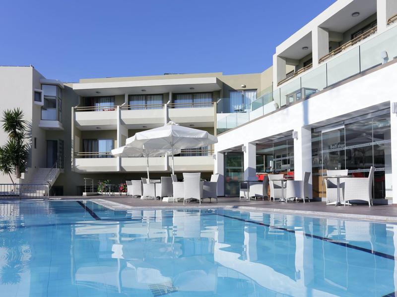 Moderne hotelzwembad met parasols en glazen relingen op een zonnige dag