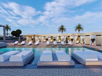 Moderne hotelzwembad met ligbedden, parasols en palmbomen onder een blauwe lucht.