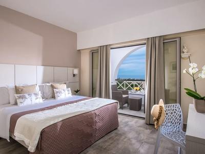 Modernes Schlafzimmer mit großem Bett, Balkon, Meerblick und heller, gemütlicher Einrichtung.