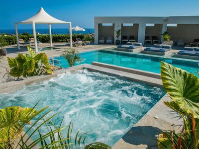 Poolanlage mit Whirlpool, Liegen und Sonnenschutz in sonniger Lage mit Meerblick