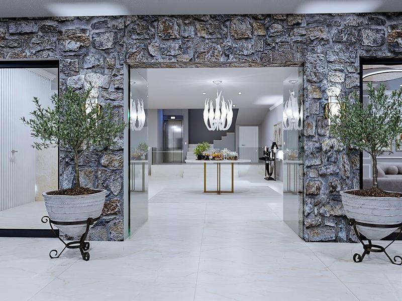 Moderner Eingangsbereich mit Steinmauern, zwei Olivenbäumen in Töpfen und hellem Bodenbelag.