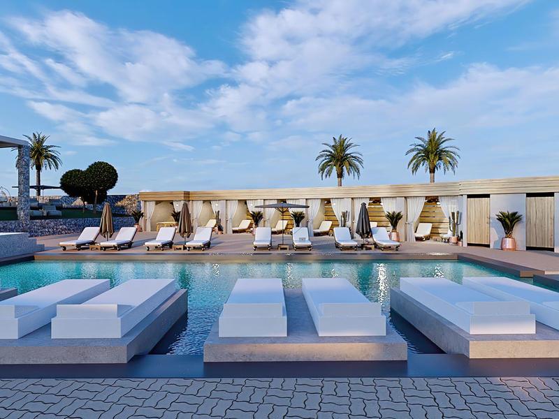 Moderner Außenpool mit weißen Liegen, Sonnenschirmen und Palmen unter blauem Himmel.