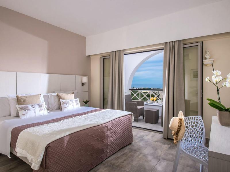 Modernes Schlafzimmer mit großem Bett, Balkon, Meerblick und heller, gemütlicher Einrichtung.