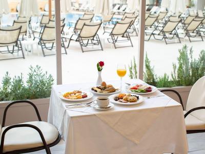 Stůl s jídlem a pitím na terase s výhledem na lehátka.