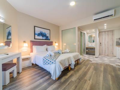 Moderní hotelový pokoj se dvěma jednolůžky, psacím stolem a dřevěnou podlahou.