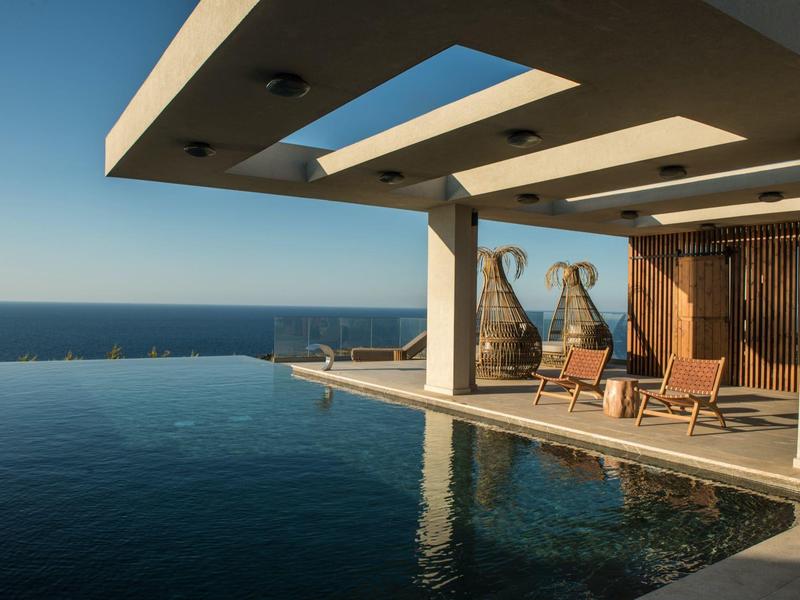 Modern infinity pool overlooking the sea on a sunny day.