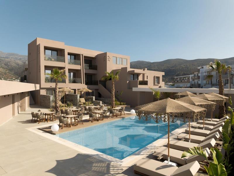 Nowoczesny hotel z basenem na zewnątrz, leżakami i parasolami w górskim rejonie.