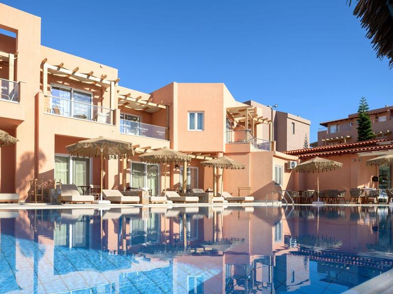 Nowoczesny budynek hotelowy z balkonami i czystym niebieskim basenem pod słonecznym niebem.