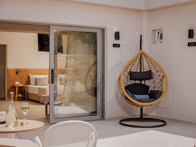 Moderner Balkon mit Schaukelei, Glastisch und offener Tür zum gemütlichen Wohnzimmer.