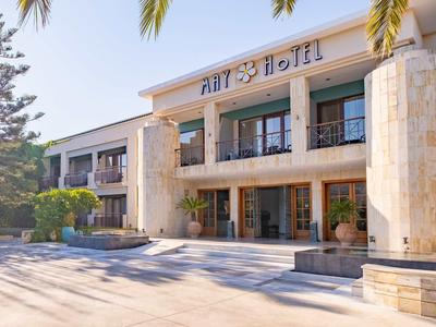 Nowoczesny budynek hotelu z dwukondygnacyjną fasadą i kolumnami przy wejściu.