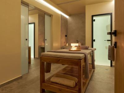 Moderne massageruimte met twee tafels, warm licht en houten details