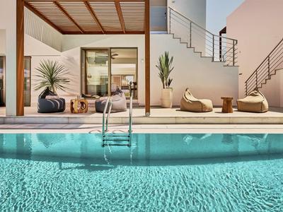 Modern pool area with cozy seating and clear blue water in a hotel.
