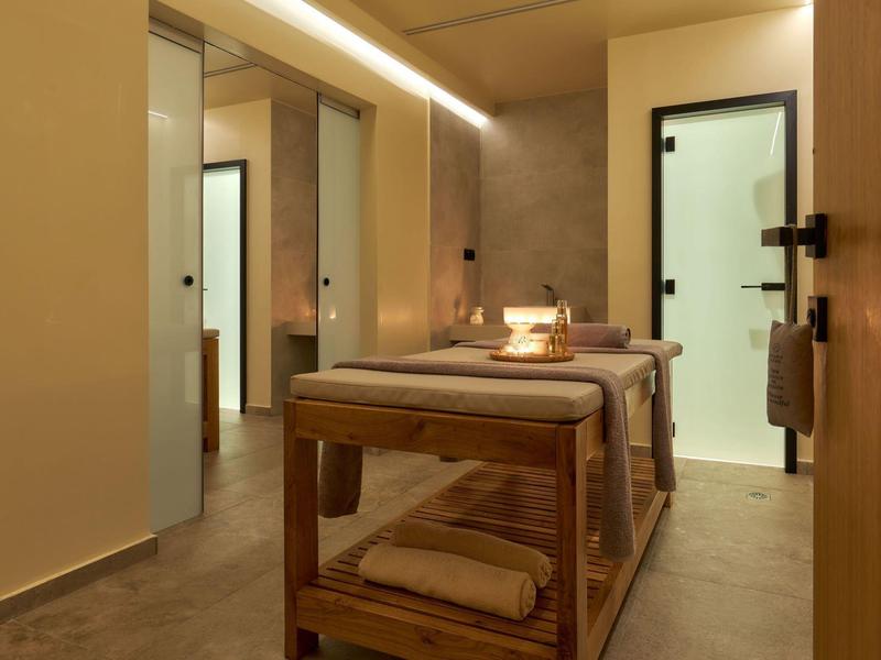 Moderne massageruimte met twee tafels, warm licht en houten details