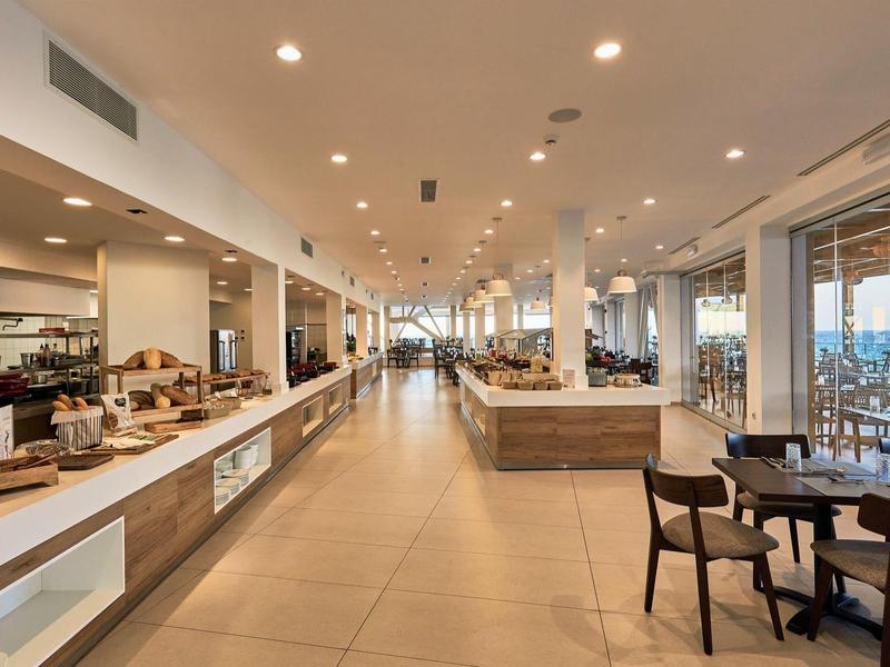 Moderne hotellobby met buffetgedeelte en zitplaatsen, grote ramen met uitzicht.