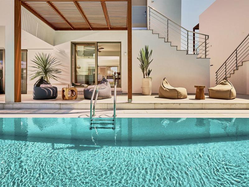 Moderne buitenruimte met zwembad, zitplaatsen en toegang tot een huis.