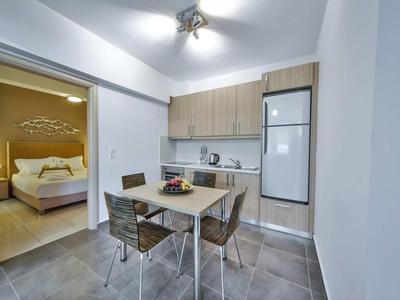 Cuisine moderne avec table à manger et vue sur une chambre avec lit double.