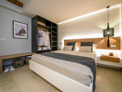 Dormitorio moderno con cama doble, armario abierto e iluminación suave