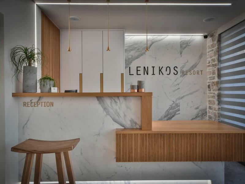 Réception d'hôtel moderne avec accents en marbre et bois, design épuré.