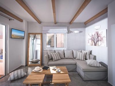 Modern living room with gray sectional sofa, wooden coffee table, and wall-mounted TV.