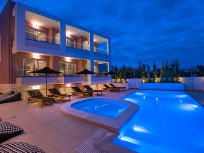 Moderní hotel s osvětleným bazénem a lehátky v noci