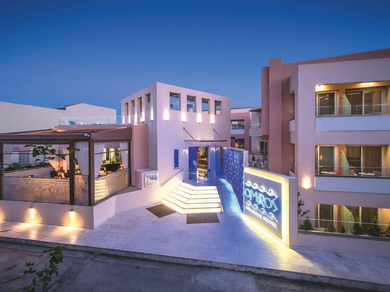 Modern hotel exterior with terraces and illuminated blue decorative panels at dusk.