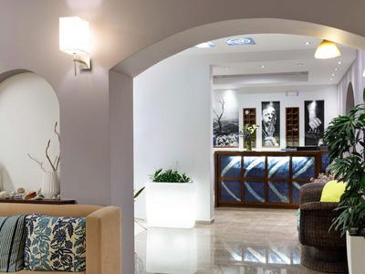 Nowoczesna lobby hotelowa z recepcją, miejscami do siedzenia i dekoracyjnymi roślinami.