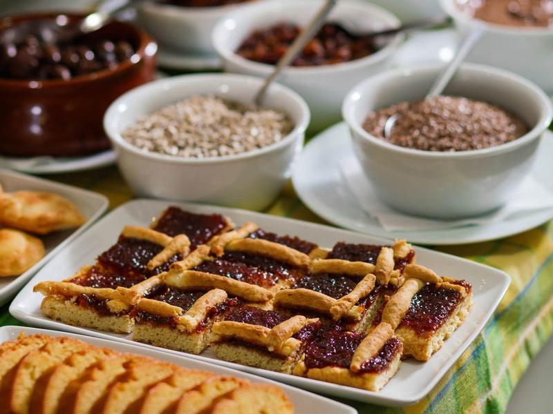 Stół z zestawem dżemów, nasion i chleba na śniadanie.