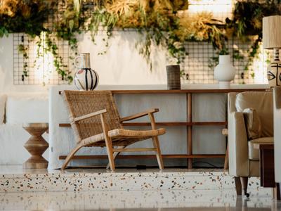 Przytulny drewniany fotel z rattanu w stylowym, jasnym wnętrzu z roślinami.