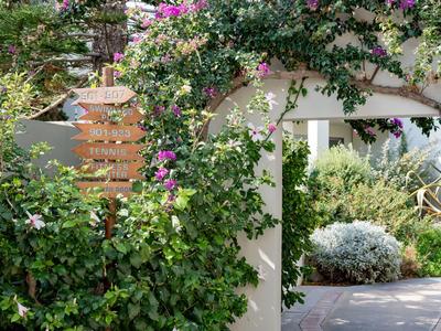 Arco coperto da piante in fiore circondato da un giardino curato in un resort per vacanze.